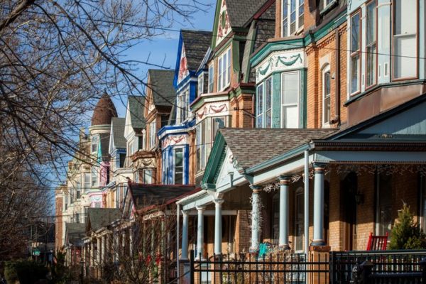 A row of houses with colorful trim and windows.