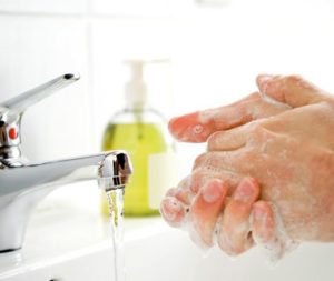 A person washing their hands in the sink.