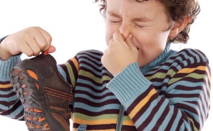 A child holding something in his hand and touching it to the side.