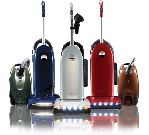 A group of vacuum cleaners sitting on top of a table.