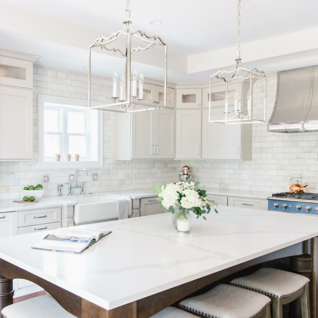 A kitchen with white cabinets and a large island.