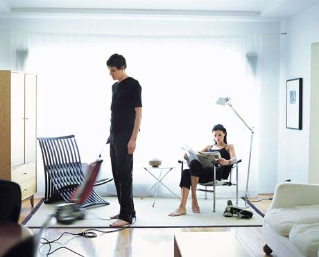 A man and woman in black shirts standing on the floor.