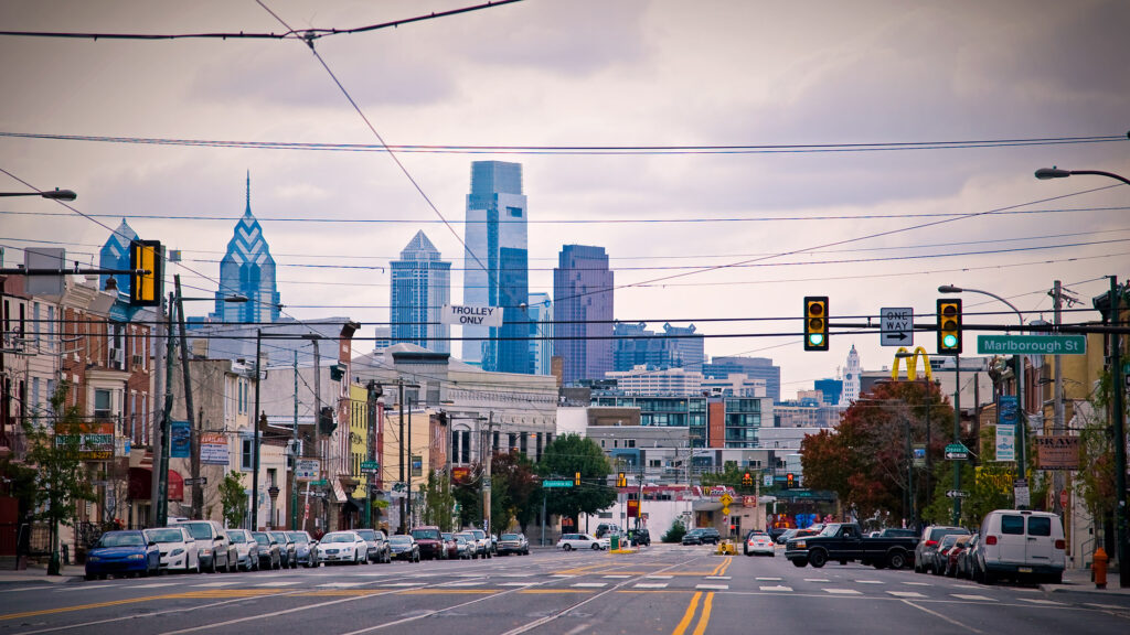 A city street with cars and buildings in the background.