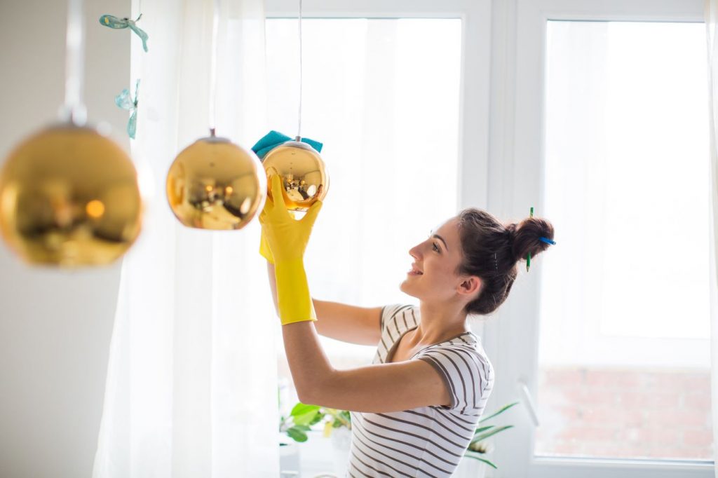 A woman in yellow gloves holding onto some bells